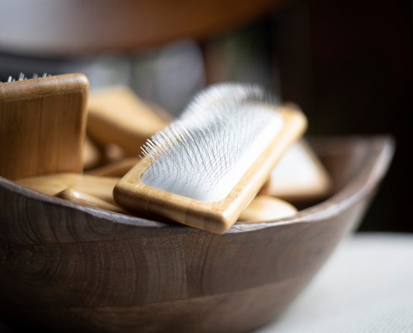 Houten kom met verzorgingsborstels en kammen